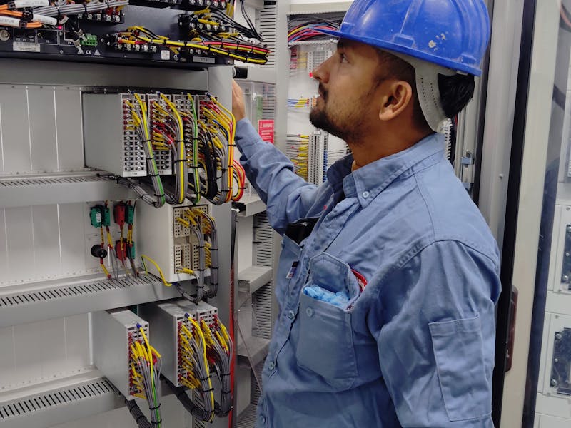 Electricien verifiant un panneau de controle a Nice